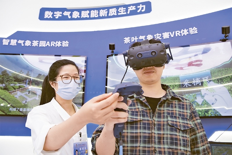 2024年5月23日，第七屆數(shù)字中國(guó)建設(shè)峰會(huì)現(xiàn)場(chǎng)體驗(yàn)區(qū)在福州海峽國(guó)際會(huì)展中心向?qū)I(yè)觀眾開(kāi)放。本次現(xiàn)場(chǎng)體驗(yàn)區(qū)圍繞本屆峰會(huì)主題“釋放數(shù)據(jù)要素價(jià)值，發(fā)展新質(zhì)生產(chǎn)力”，設(shè)置“數(shù)字惠民”、“數(shù)字能力”、“數(shù)字基礎(chǔ)”、“數(shù)字生態(tài)”、“數(shù)字賦能”五大板塊。圖為一名觀眾（右）在數(shù)字氣象賦能新質(zhì)生產(chǎn)力展臺(tái)上進(jìn)行體驗(yàn)。 新華社記者 魏培全/攝