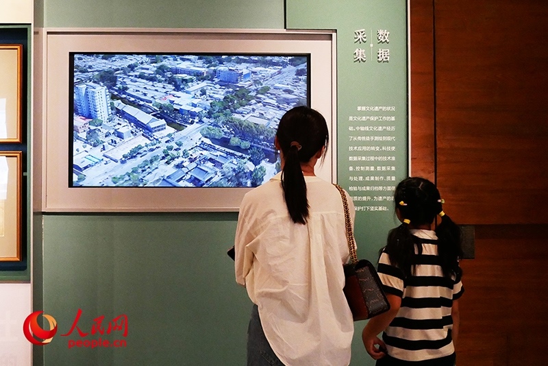 家長正在帶孩子參觀“輝煌中軸”專題展。人民網(wǎng)記者 韋衍行攝