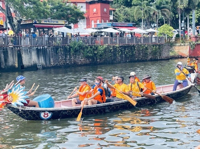 多元種族共同奮輯前進(jìn)，體驗在馬六甲河劃龍舟，引來大批游客駐足圍觀。組委會供圖