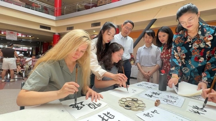 羅馬尼亞友人在活動現(xiàn)場學(xué)寫漢字。中國駐羅馬尼亞大使館領(lǐng)僑處供圖
