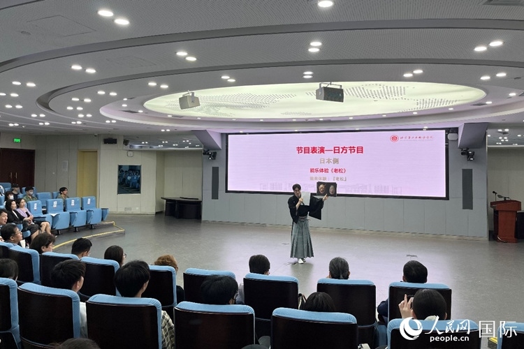 日本大學(xué)生介紹能樂知識。人民網(wǎng)記者 陳思攝