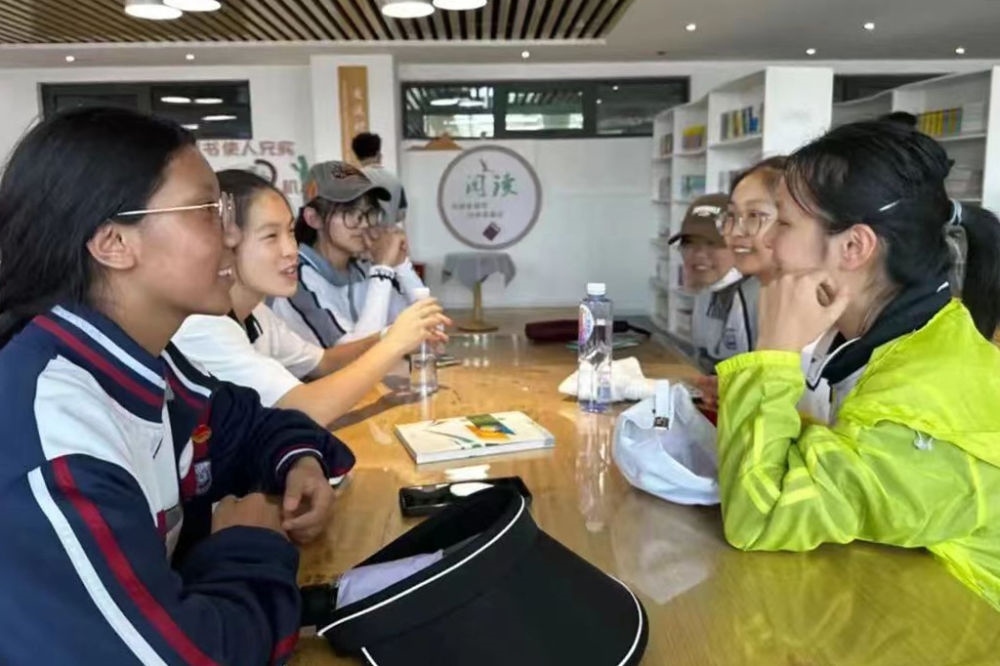 2023年7月10日，在果洛西寧民族中學，上海市大同中學學生（右）與果洛西寧民族中學學生交流。新華社發(fā)（果洛州教育局供圖）