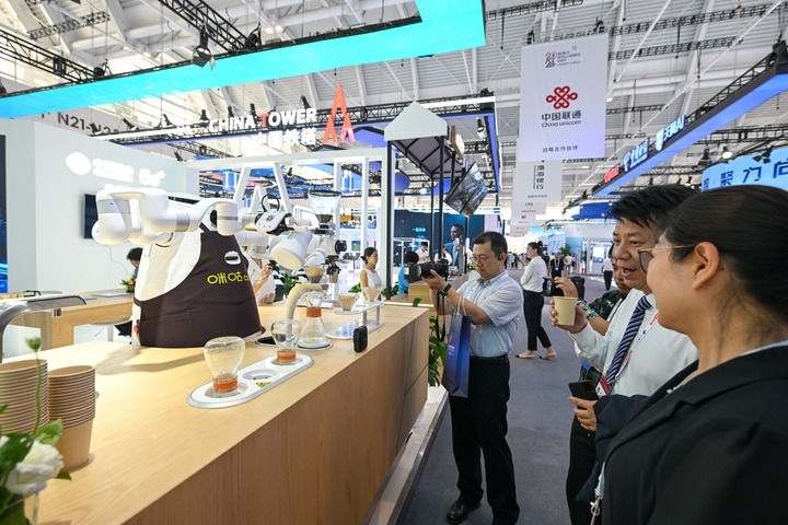 6月20日，與會者品嘗機器人沖調(diào)出的咖啡。新華社記者 孫凡越 攝