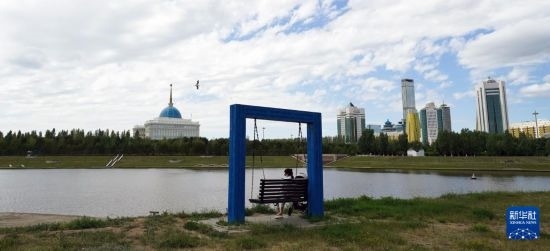 6月30日，一名女子在哈薩克斯坦首都阿斯塔納伊希姆河畔休息。新華社記者 王建華 攝