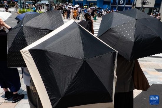 7月4日，人們在日本東京原宿的街道上等待紅綠燈。新華社記者 張笑宇 攝