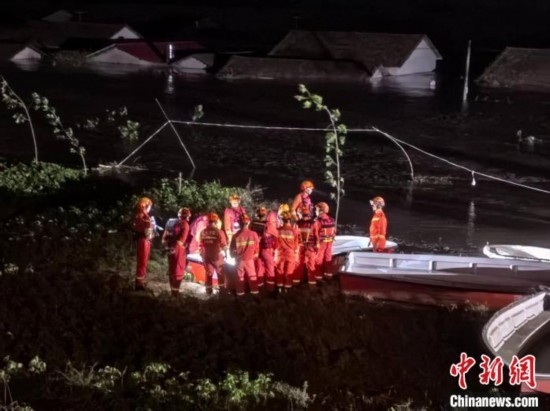  7月6日凌晨3時(shí)，在湖南岳陽華容縣團(tuán)洲垸洞庭湖一線堤防，救援人員剛剛完成一次救援任務(wù)，遠(yuǎn)處是被淹的民房。中新社記者 白祖偕 攝