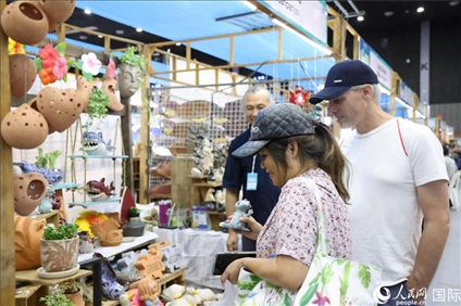 游客在蘭納博覽會(huì)特色展位上選購(gòu)工藝品。人民網(wǎng)記者楊一攝