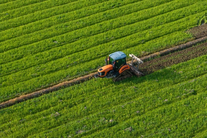 2024年3月19日，在湖南省常德市鼎城區(qū)謝家鋪鎮(zhèn)港中坪村，村民駕駛農(nóng)機翻耕田地（無人機照片）。新華社記者 陳思汗 攝