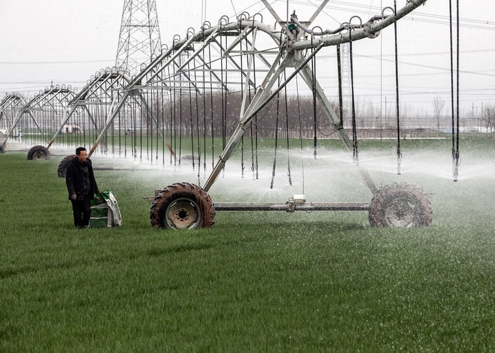 2024年3月18日，在河南省焦作市博愛縣孝敬鎮(zhèn)東原莊村瑞輝家庭農(nóng)場，村民使用全自動指針式噴灌機進行澆灌作業(yè)。新華社發(fā)（程全攝）