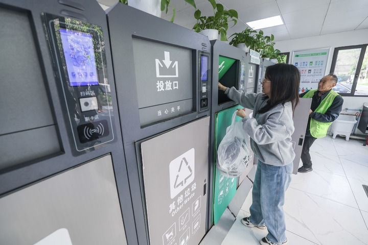 2024年4月10日，在浙江省湖州市吳興區(qū)飛英街道新華府小區(qū)內(nèi)，居民在垃圾分類智能系統(tǒng)的指導下進行垃圾分類投放，居民的投放情況將實時匯總到智慧服務平臺，會有相應的積分獎勵。新華社記者 徐昱 攝