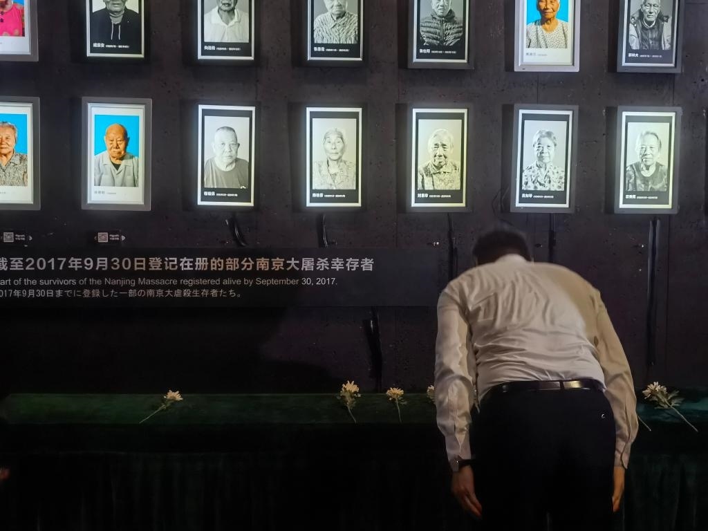 7月18日，人們向離世的南京大屠殺幸存者獻花、鞠躬。新華社記者邱冰清 攝