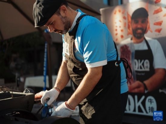 7月19日，在蕪湖古城，馬丁在當(dāng)天舉行的啤酒節(jié)上制作牛排。新華社發(fā)（繆雨晨 攝）