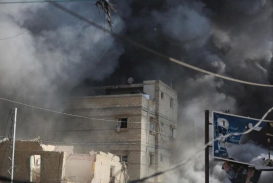 7月21日，在加沙地帶中部的努賽賴特難民營(yíng)，遭以軍空襲的建筑冒出滾滾濃煙。新華社發(fā)（馬爾萬(wàn)·達(dá)烏德攝）