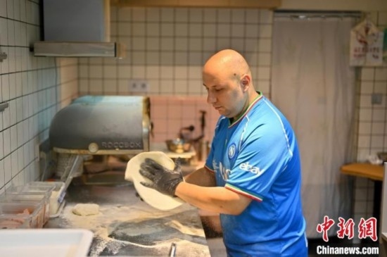 近日，韋榮耀在自家披薩小店內(nèi)忙活。俞靖 攝