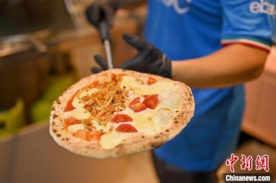 近日，韋榮耀展示他制作的“老友味”披薩。 俞靖 攝