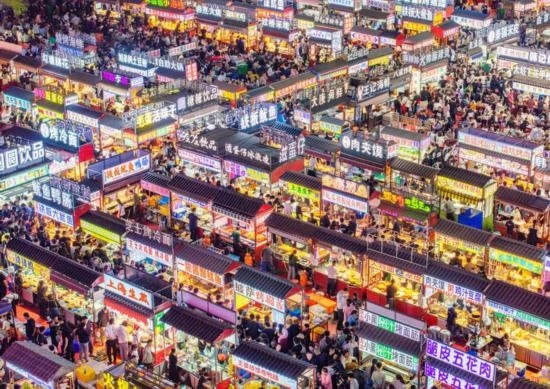 2024年4月21日，人們?cè)诤颖笔≌h小商品夜市品嘗美食（無人機(jī)照片）。新華社發(fā)（武志偉 攝）