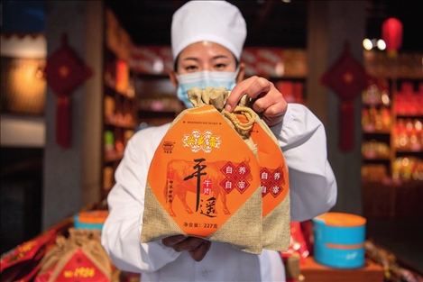 在位于山西省晉中市平遙縣的平遙古城南大街的一家平遙牛肉店內(nèi)，工作人員展示一款牛肉產(chǎn)品（資料照片）楊晨光攝 / 本刊