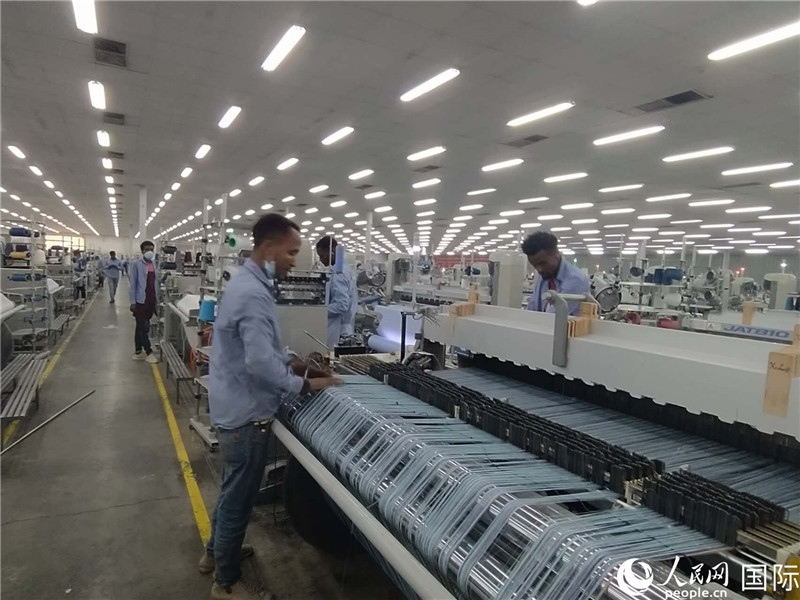 無錫金茂埃塞面料廠車間內(nèi)，當(dāng)?shù)毓と苏谝唤z不茍地作業(yè)。人民網(wǎng)記者 黃培昭攝