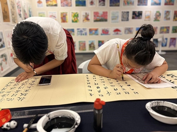 參加本次展覽的青少年在現(xiàn)場進(jìn)行書法創(chuàng)作。主辦方供圖