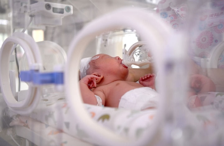 2024年6月1日，在西安國際醫(yī)學(xué)中心醫(yī)院新生兒科病房，護士為新生兒喂奶。 新華社記者 劉瀟 攝