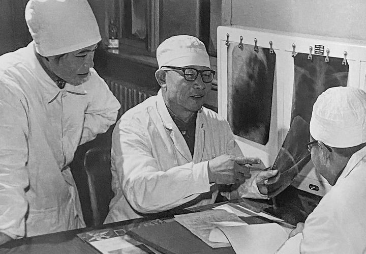 1980年1月16日，中日友好醫(yī)院首任院長辛育齡（中）在內(nèi)蒙古結(jié)核病院與胸外科醫(yī)師討論病例（翻拍照片）。 新華社發(fā)