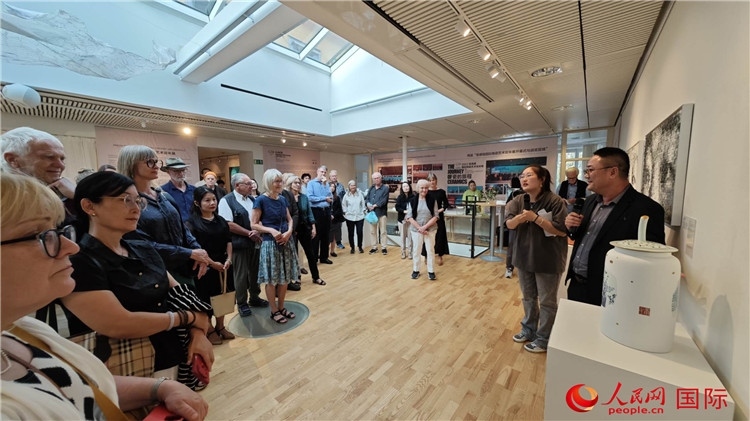 參展人、景德鎮(zhèn)陶瓷大學(xué)美術(shù)學(xué)院副院長邵長宗（右一）向來賓介紹參展作品。人民網(wǎng)記者 殷淼攝