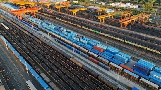 這是2024年8月14日在黑龍江綏芬河鐵路口岸集裝箱換裝場拍攝的集裝箱換裝作業(yè)現(xiàn)場（無人機照片）。今年前七個月，綏芬河鐵路口岸開行中歐班列573列，運量達(dá)55246標(biāo)箱，同比分別增長23%和18%，班列數(shù)量持續(xù)保持高位運行。