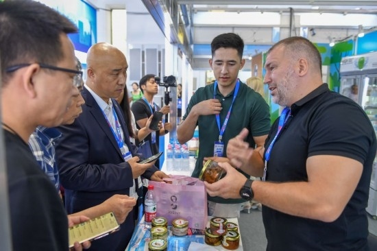2023年8月23日，在第十四屆中國—東北亞博覽會東北亞商品館，俄羅斯參展商向參觀者介紹商品。
