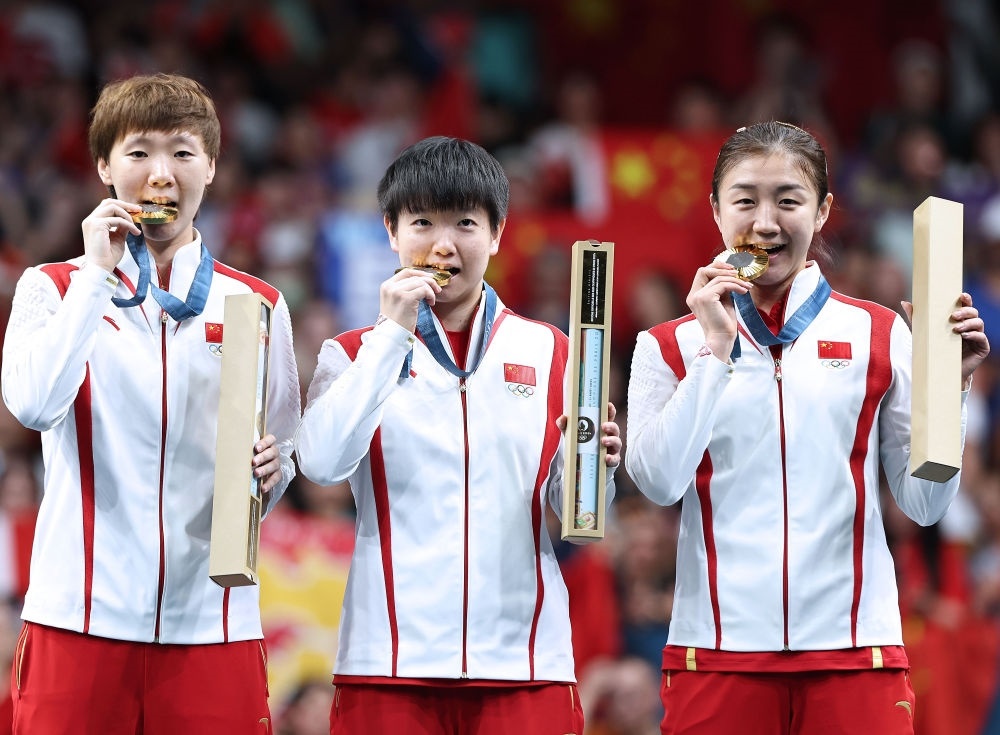 冠軍中國隊選手王曼昱、孫穎莎、陳夢（從左至右）在巴黎奧運會乒乓球女子團體頒獎儀式上（2024年8月10日攝）。新華社記者 王東震 攝