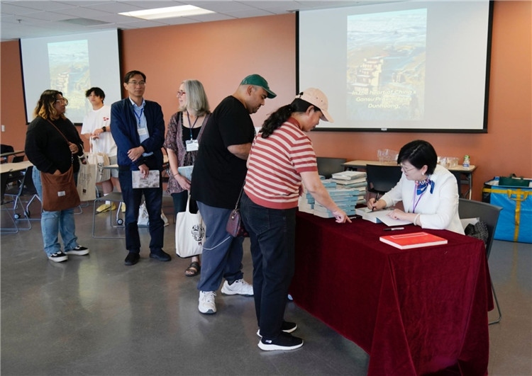 作者顧春芳在活動現(xiàn)場簽名贈書。羅先勇攝