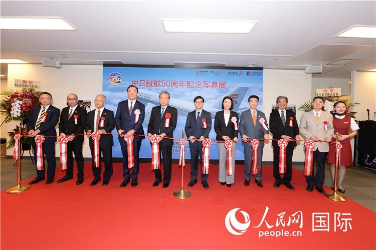 與會嘉賓共同為中日通航50周年紀(jì)念圖片展開幕剪彩。馮學(xué)敏攝