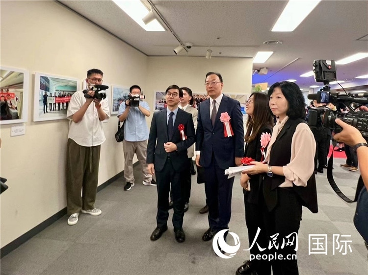 中國國際航空日韓地區(qū)支社支社長馮力為中國駐日本大使館臨時代辦施泳等嘉賓介紹展出圖片。人民網(wǎng) 許可攝