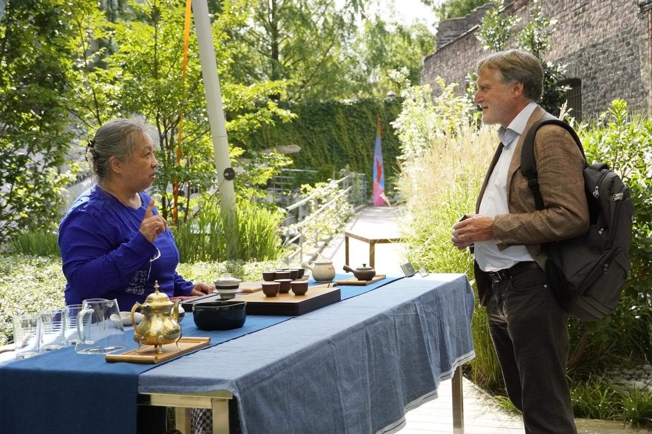 在博物館的戶外花園來賓品味中國茶藝。比利時維他命文化傳媒供圖