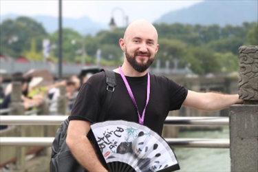 俄羅斯塔斯社執(zhí)行編輯葉夫根尼·扎多羅日內(nèi)在都江堰魚嘴拍照留念。（李佩藺 攝）