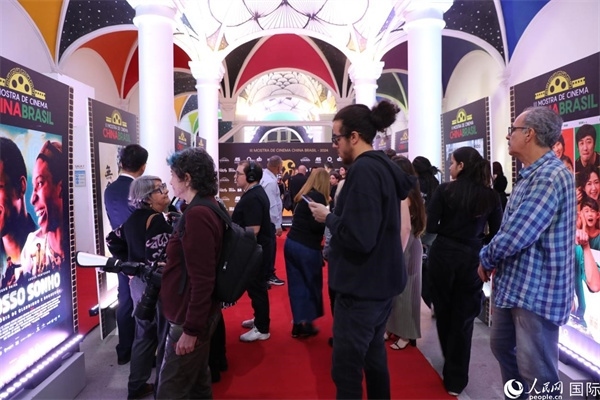 為期4天的第三屆中國－巴西電影展期間，來自中巴兩國的14部參展影片受到巴西電影愛好者和社會各界人士好評，圖為當(dāng)?shù)赜^眾在影展舉辦地巴西里約熱內(nèi)盧勞拉—阿爾維姆文化之家的迎賓廳欣賞參展電影海報(bào)。 人民網(wǎng)記者 陳一鳴攝