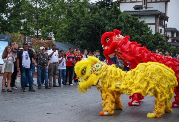 2024“一帶一路”媒體合作論壇聯(lián)合采訪調(diào)研行成員在樂山蘇稽古鎮(zhèn)觀看非遺舞獅表演。本報(bào)記者 伊霄攝