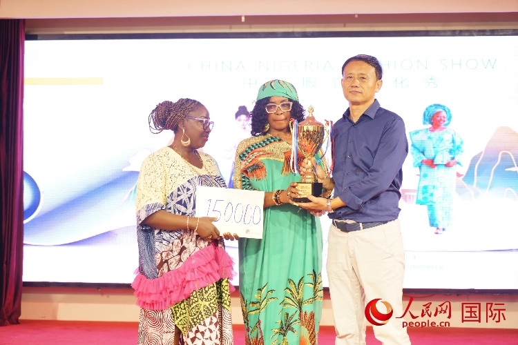 中國(guó)駐尼日利亞使館文化參贊兼中國(guó)文化中心主任李旭大（右）為最佳表現(xiàn)獎(jiǎng)?lì)C獎(jiǎng)（中）。人民網(wǎng)記者 姜宣攝