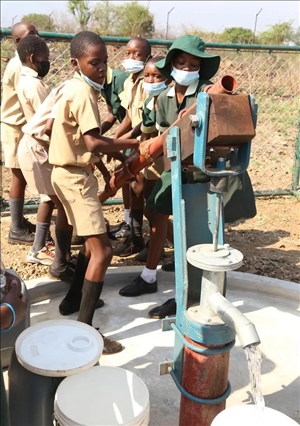 △2021年11月，在津巴布韋南馬塔貝萊蘭省省會(huì)關(guān)達(dá)的塞農(nóng)多小學(xué)，學(xué)生從中國(guó)援建水井里打水。