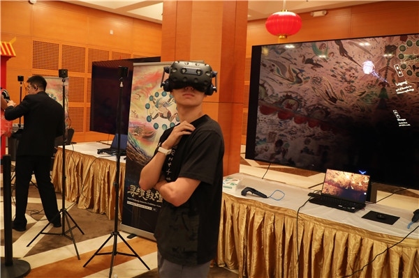 1、在本次活動的展覽現(xiàn)場，敦煌研究院與騰訊展示了“數(shù)字藏經洞”和“尋境敦煌”等創(chuàng)新互動產品。圖為當?shù)孛癖娡ㄟ^VR虛擬游覽洞窟。 人民網(wǎng)記者 李志偉攝