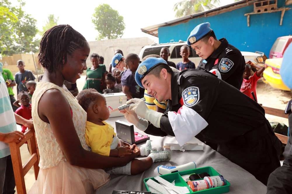 2017年12月28日，在利比里亞蒙羅維亞，中國維和警察防暴隊醫(yī)療人員為兒童做口腔檢查。