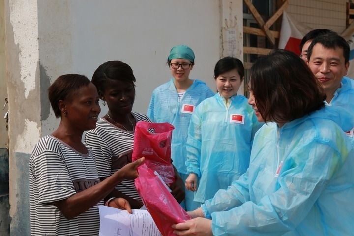 2015年4月4日，在位于塞拉利昂首都弗里敦市郊的中塞友好醫(yī)院埃博拉診療中心，中國第四批援塞醫(yī)療隊副隊長邵蔚（右前）向被治愈的埃博拉出血熱患者贈送禮物。新華社發(fā)（祖榮強 攝）