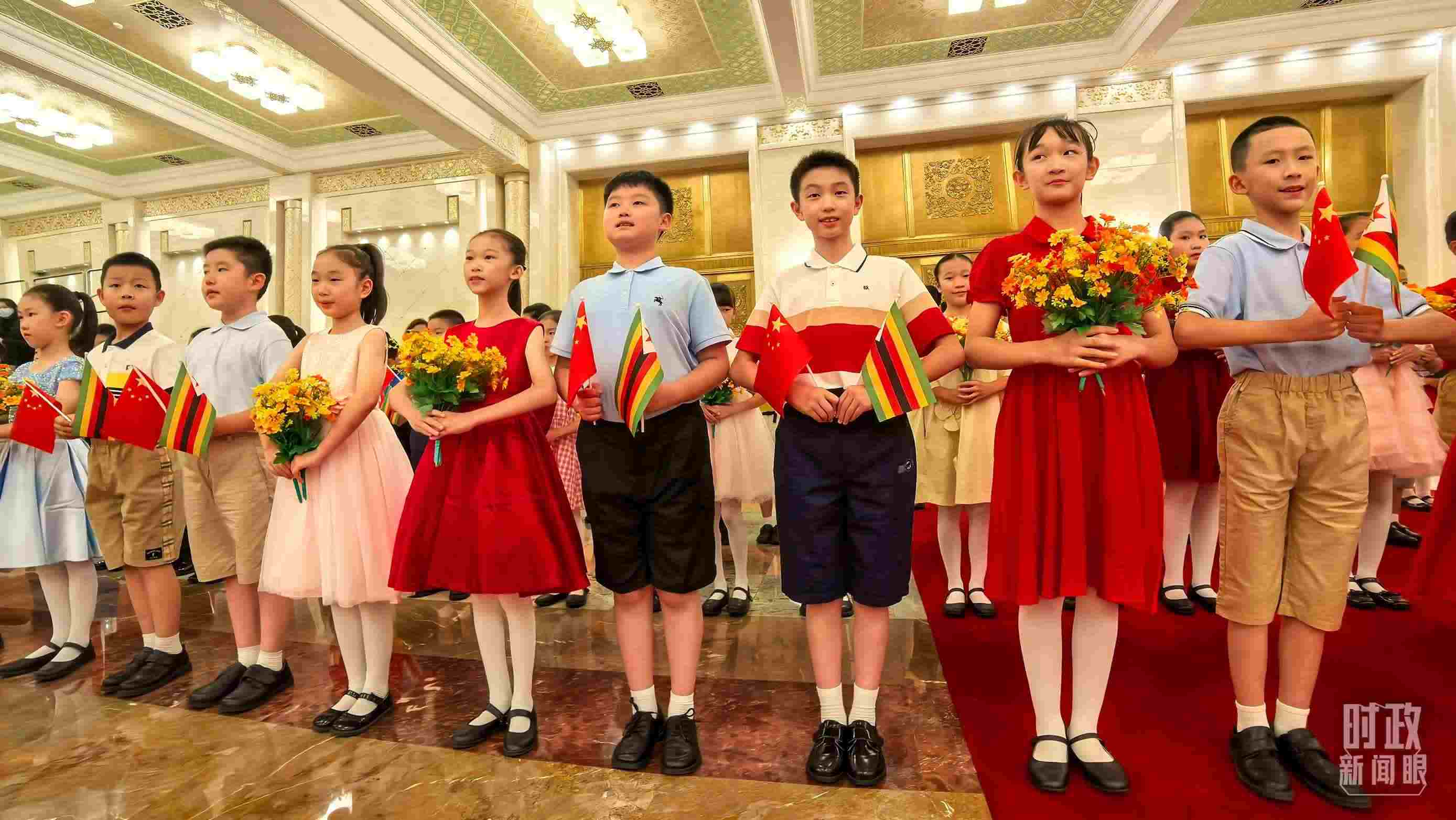 △現(xiàn)場(chǎng)歡迎津巴布韋總統(tǒng)訪華的青少年。（總臺(tái)央視記者鐘銳拍攝）