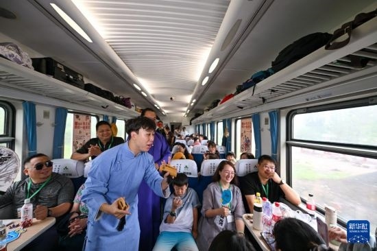 9月7日，相聲演員在S910列車上為旅客表演快板。
