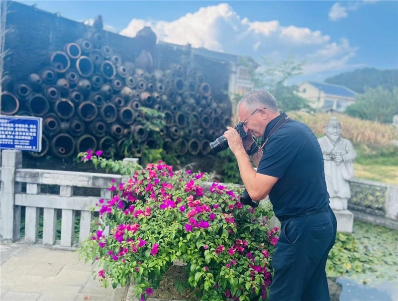 遠(yuǎn)處黔北民居錯(cuò)落有致，近處一只黑色的蝴蝶穿梭于粉紫色三角梅花叢間隙，與俄羅斯“大歐亞”總編輯弗拉基米爾·別列日內(nèi)赫的鏡頭玩起了捉迷藏，“你追我逃，不亦樂乎”。（張亞欣攝）