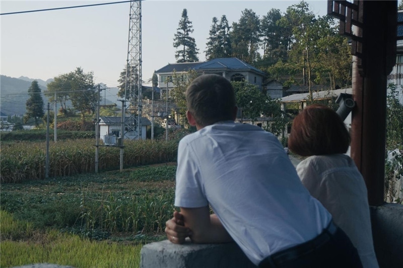 望得見山，看得見水，記得住鄉(xiāng)愁。每個(gè)人心中都有一個(gè)屬于自己的“花茂村”，在這方心田，走遍千山萬水，鄉(xiāng)音未改鬢毛衰。吉爾吉斯斯坦《比什凱克晚報(bào)》第一副總編輯妮娜·尼奇博洛娃與《中國與俄羅斯》雜志社社長奧列格·別列日內(nèi)赫攝在花茂村民居屋檐下并肩佇立，眺望山水，尋覓鄉(xiāng)愁。（李光裕攝）