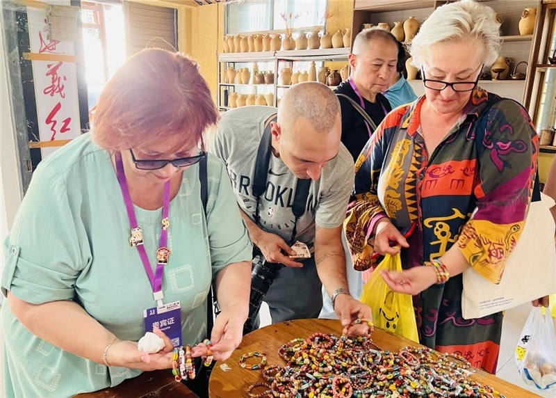 歐亞媒體考察團(tuán)成員在母氏陶藝館內(nèi)挑花了眼，色彩絢麗、質(zhì)地均勻的陶藝手串讓他們愛不釋手?！斑@里的東西都太實(shí)惠了！”塔吉克斯坦《索格特真理報(bào)》政論部主任娜塔利婭·多羅費(fèi)耶娃說。花茂村的特色產(chǎn)品物美價(jià)廉，讓考察團(tuán)成員為家人好友買到了心儀的禮物，也為此次以四川成都為起點(diǎn)，路經(jīng)南充、廣安至貴州遵義的考察行程畫上了圓滿句號。（張亞欣攝）