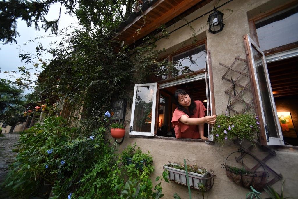 8月29日，在福建省屏南縣熙嶺鄉(xiāng)，龍?zhí)洞濉靶麓迕瘛泵泛暝诖蚶碜约航?jīng)營的民宿外墻裝飾花盆。新華社記者姜克紅 攝