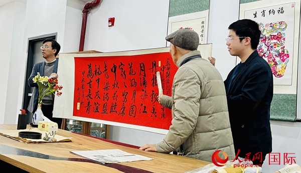 旅秘書法家向現(xiàn)場(chǎng)觀眾展示書法作品。人民網(wǎng)記者 宋亦然攝