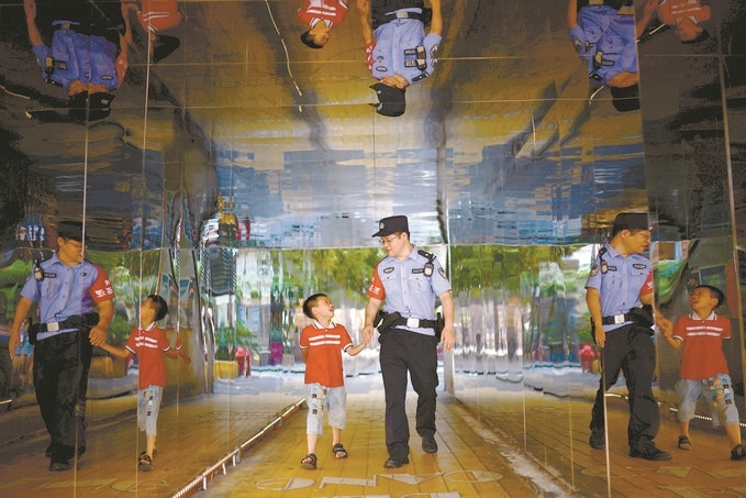 ?7月16日，重慶市公安局江北區(qū)分局一名民警在巡邏途中遇到一個(gè)獨(dú)自玩耍的小男孩，民警將其送回家。王洪平攝