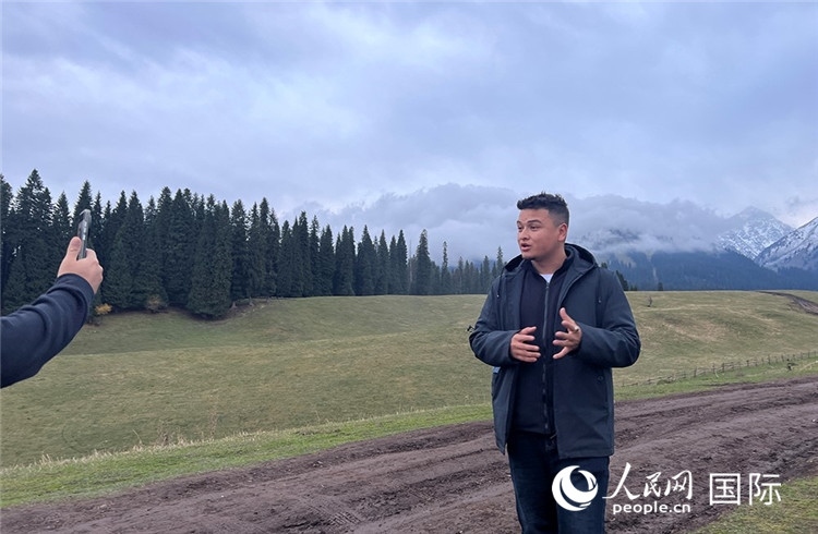 在庫爾德寧，吾買爾江被雪山美景震撼，即興錄制了短視頻作品。人民網(wǎng)記者曾書柔攝